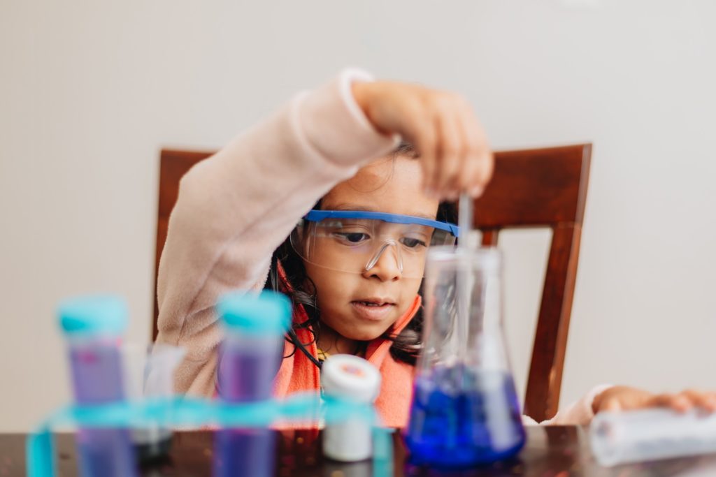 young hispanic girl conducts science experiment